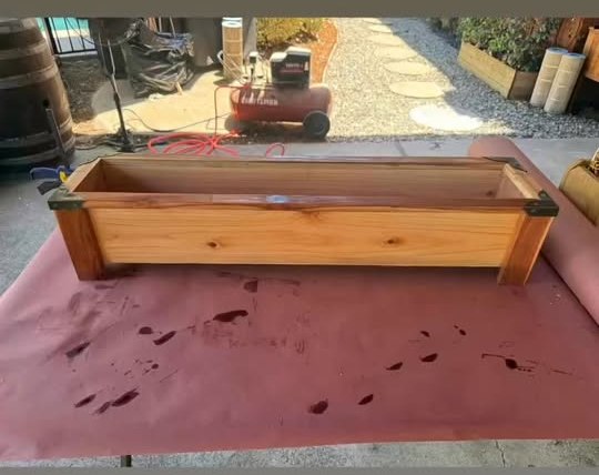 A 36-inch solid premium redwood planter box with dark metal corner brackets, sealed with natural tung oil.